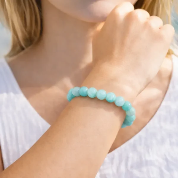 Bracelet en Amazonite turquoise naturelle porté au poignet, perles bleu lagon aux reflets soyeux sur fil élastique haute résistance.