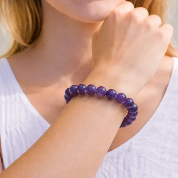 Bracelet en améthyste naturelle sur fil élastique porté au poignet