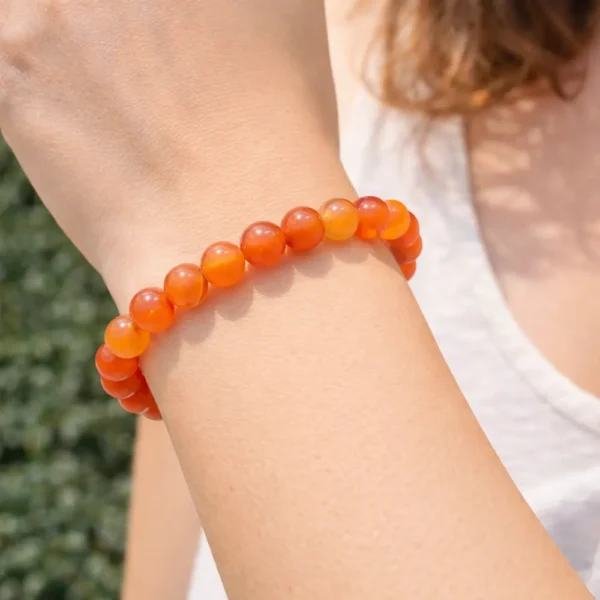 Bracelet en cornaline naturelle perles orange vif porté au poignet