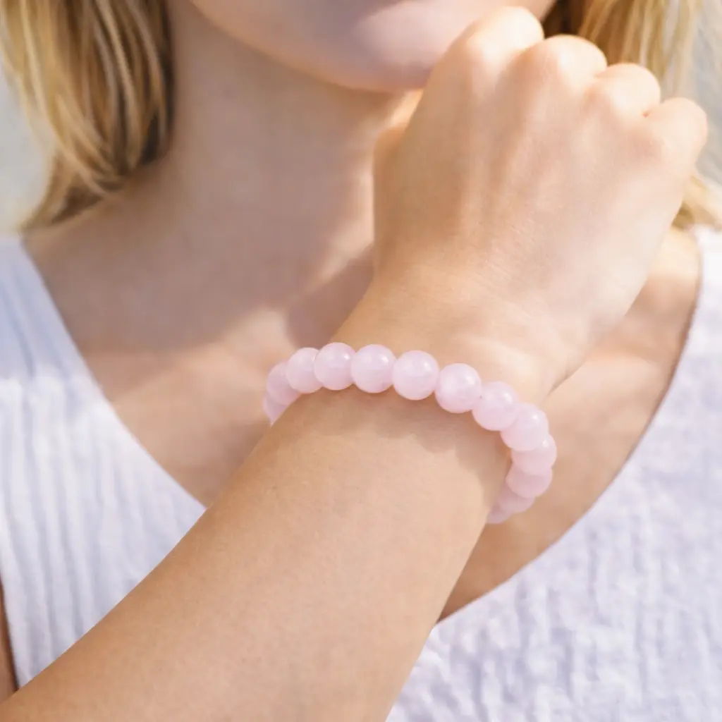 Bracelet en Quartz Rose véritable porté au poignet, perles rose poudré translucides à l'éclat vitreux, montage artisanal haute qualité.