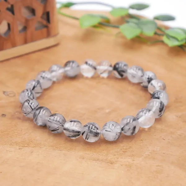 Bracelet en quartz rutile noir naturel aux perles transparentes traversées d’inclusions sombres