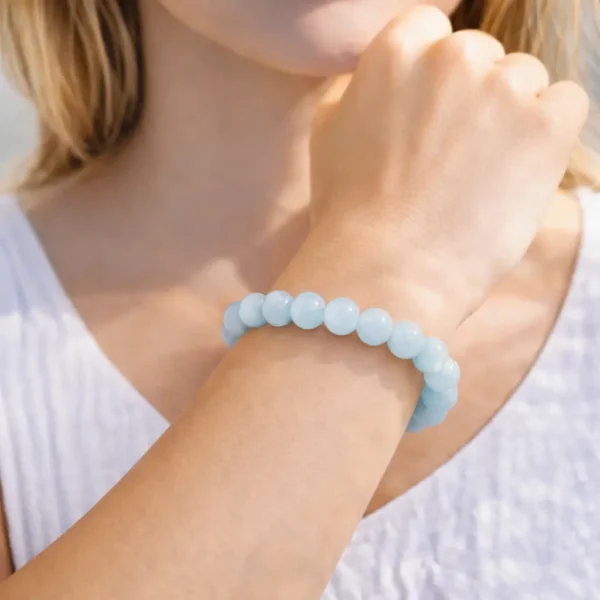 Bracelet en Aigue-Marine naturelle porté au poignet, perles translucides bleu azur et bleu ciel de qualité gemme, montage artisanal sur fil résistant.