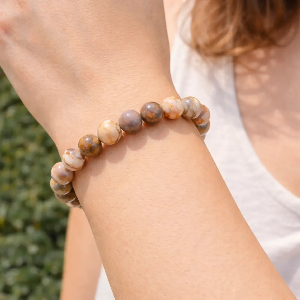 Bracelet en jaspe vénus perles tachetées roses et beiges porté au poignet féminin