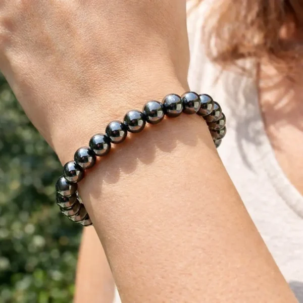 Bracelet en Hématite véritable porté au poignet, illustrant l'éclat miroir de la pierre et le design épuré de ce bijou artisanal de qualité