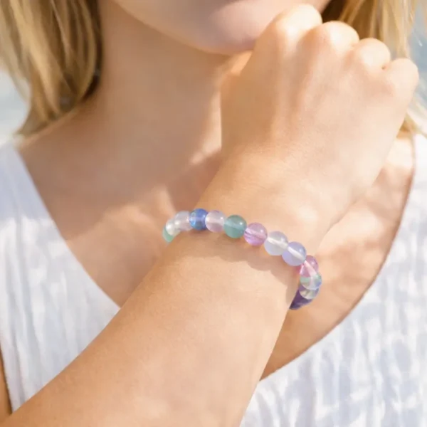 Bracelet en Fluorite véritable porté au poignet, mettant en valeur la clarté des cristaux et les nuances arc-en-ciel de ce bijou fait main.