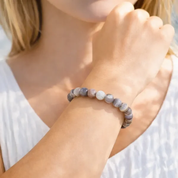 Bracelet en perles d'Agate du Botswana porté au poignet, illustrant les nuances naturelles des pierres et la qualité du montage fait main.