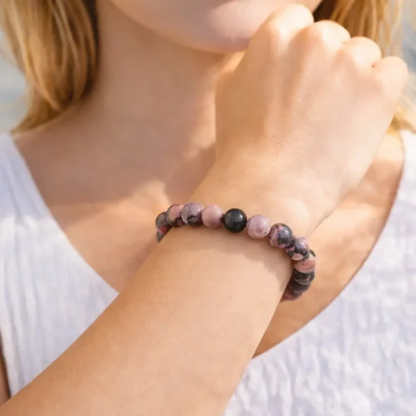 Bracelet en Rhodonite naturelle porté au poignet, perles rose poudré marbrées de noir intense sur montage artisanal résistant.