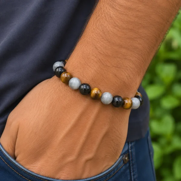 Bracelet de protection en pierres naturelles porté, avec perles de labradorite aux reflets bleus, obsidienne noire et œil de tigre.